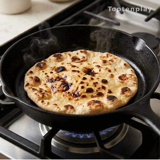 Golden flatbread with char spots cooking in a cast-iron skillet