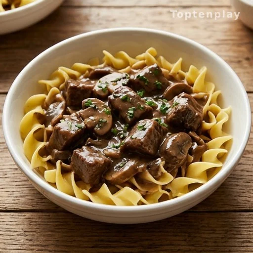 Mushroom beef tips in gravy served over egg noodles in a bowl