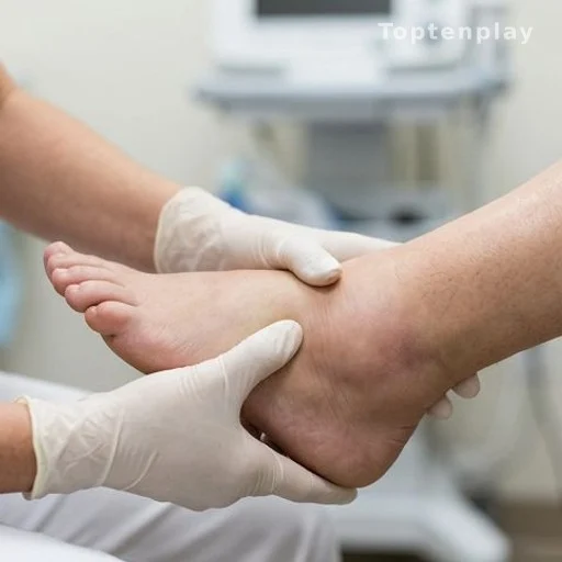 Healthcare professional examining a patient's swollen ankle in a clinic