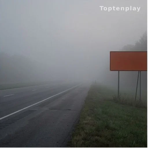 Foggy highway at dawn with low visibility and road warning sign, traffic safety conditions